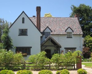 two story white home with greenery in front yard