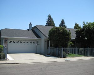 white house with attached garage, fence and new roof