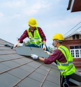 men in red wearing high vis install a roof