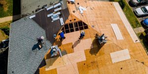 three workers working on a commercial roofing