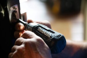 a man is using a cordless drill to open a door