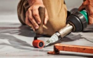 a man is using a drill to repair a floor