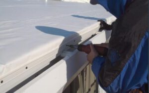 a man is using a drill to install a roof on a house