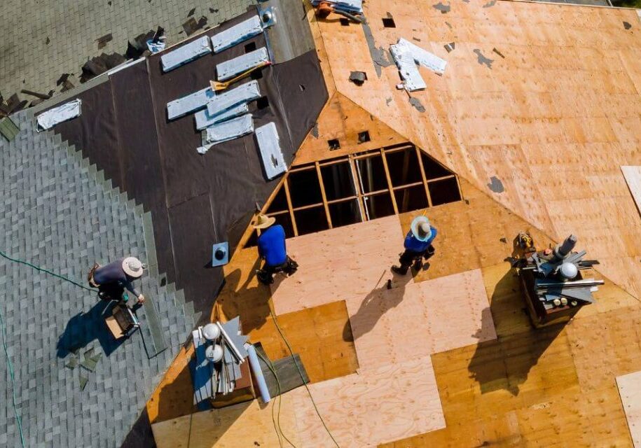 three workers working on a commercial roofing