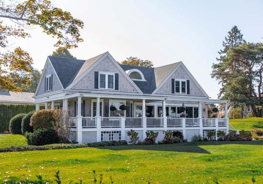 a large white house with a porch and a lawn